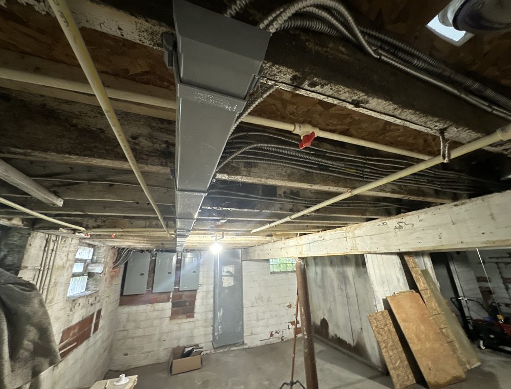 New conduit and wiring runs across a basement ceiling