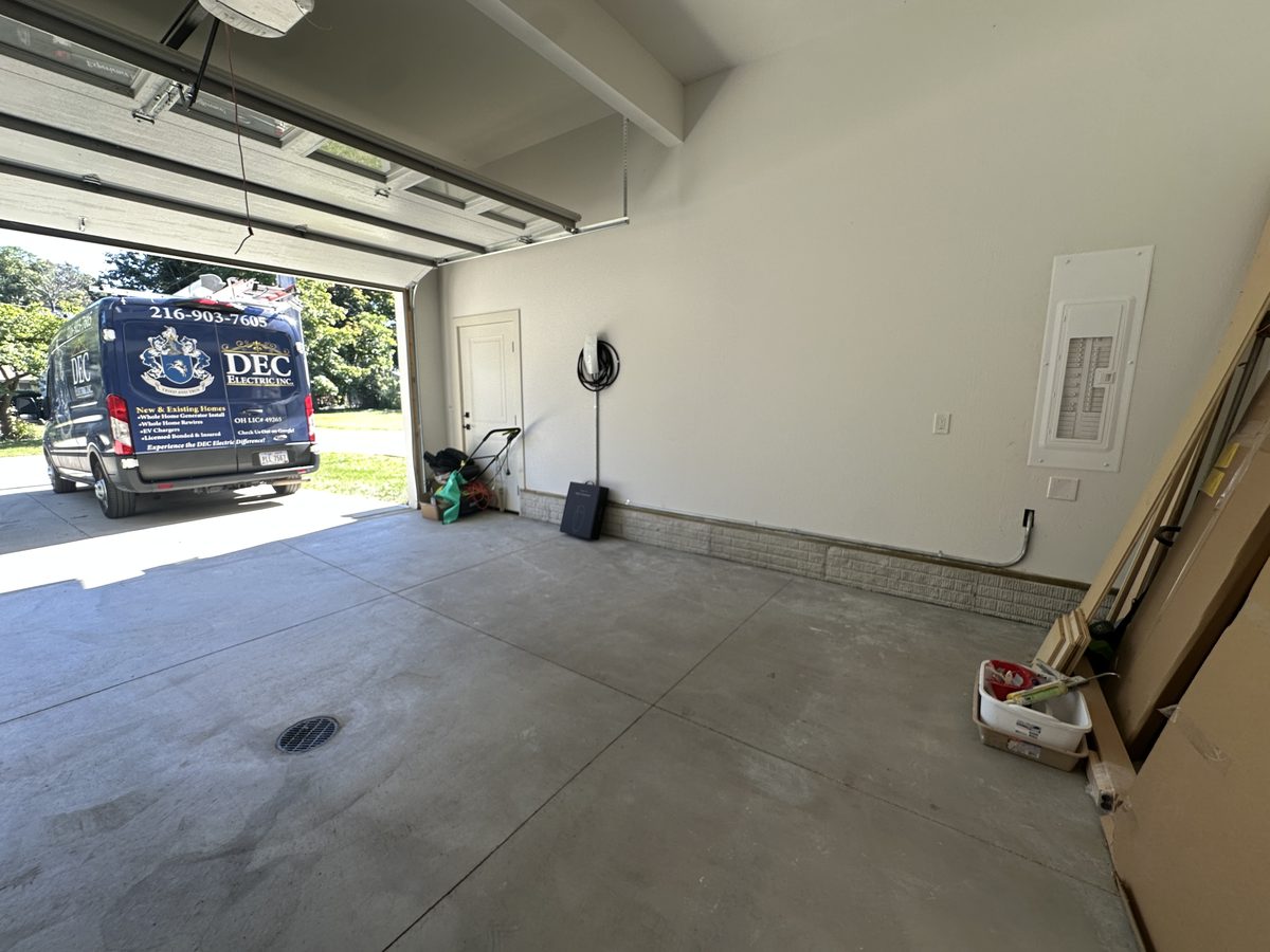 New EV charger installed on the garage wall, with the DEC Electric van in the driveway