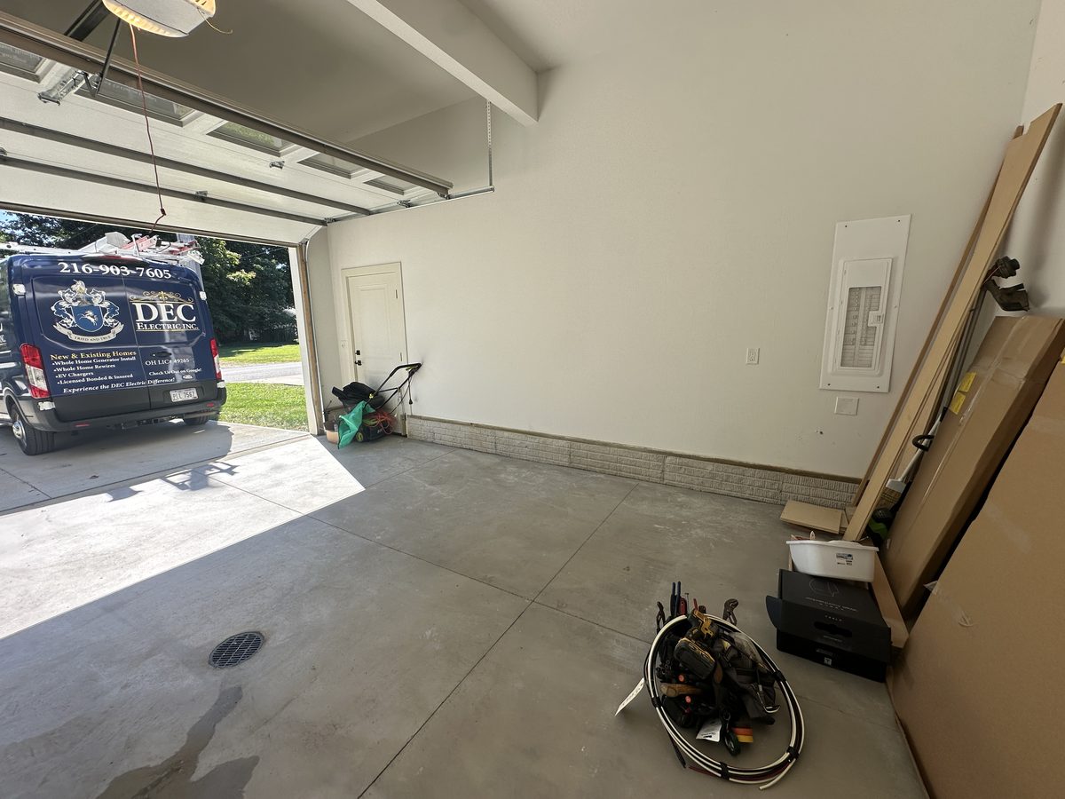 Garage wall before the EV charger installation, with the DEC Electric van in the driveway